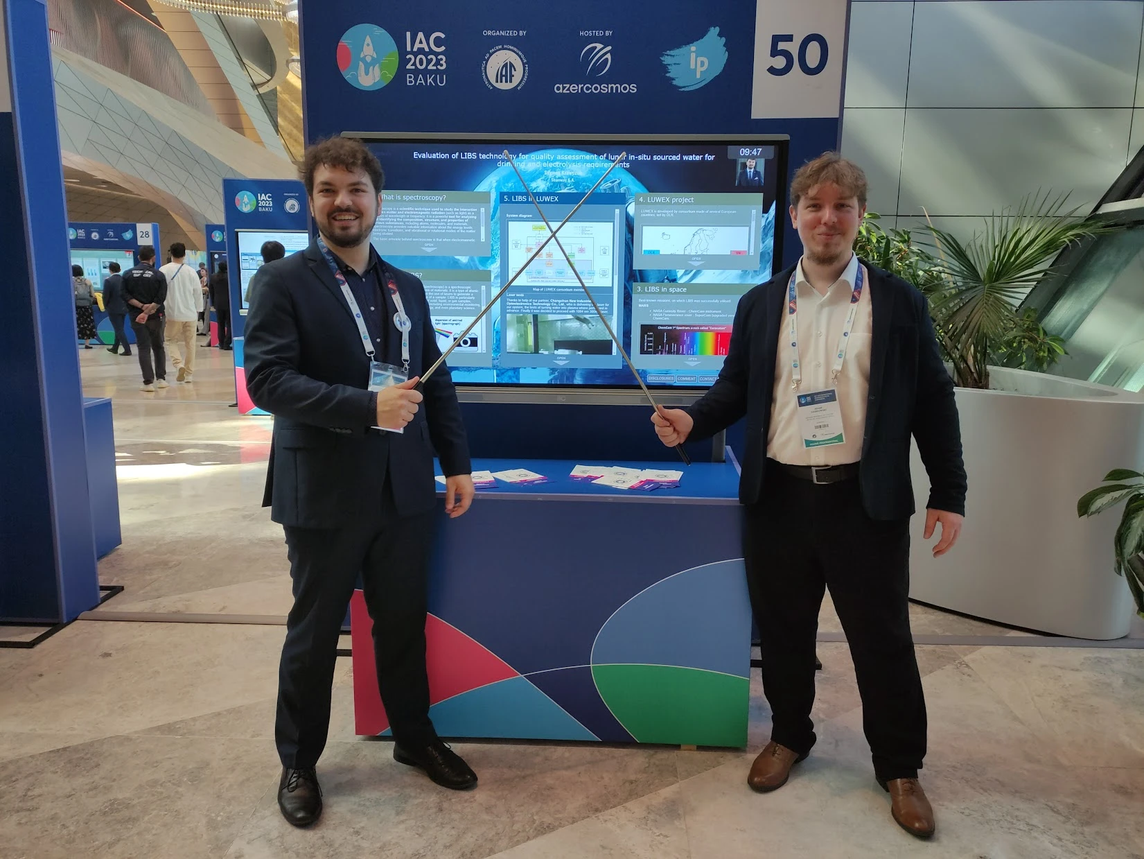 Two attendees at poster stand 50 of IAC 2023